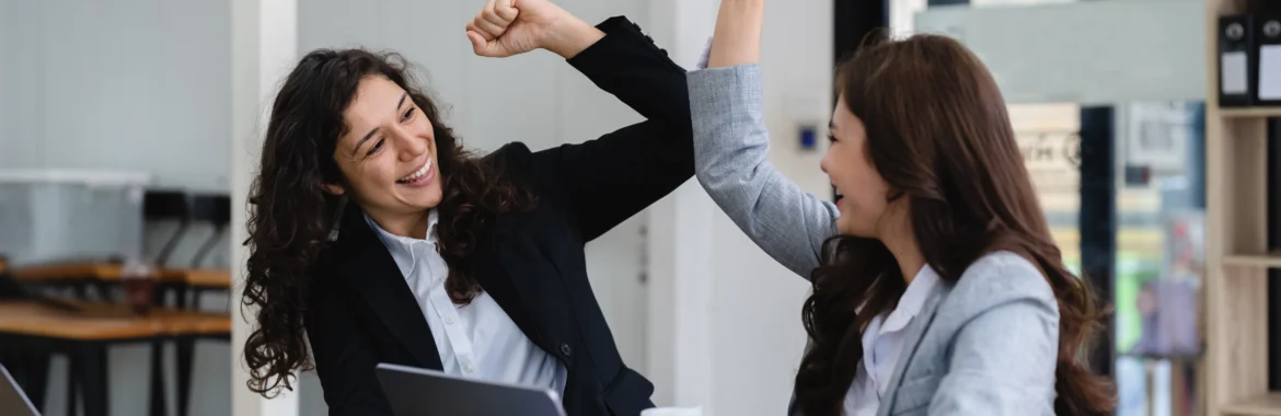 Due colleghe che festeggiano la conclusione di un lavoro portato a termine.